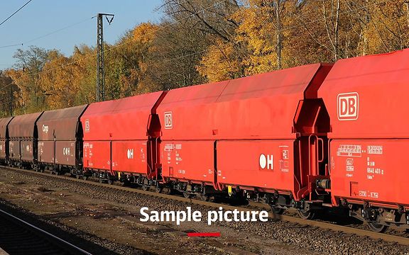 A freight train with red wagons and the signature Sample picture