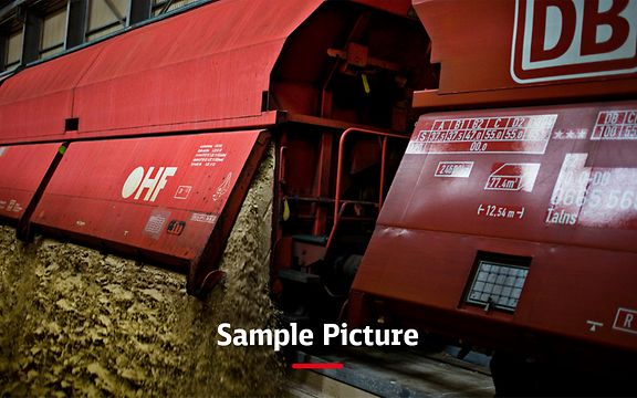 A freight train with red wagons and the signature Sample picture