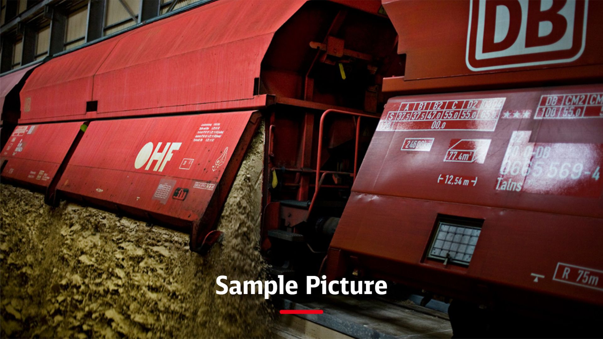 A freight train with red wagons and the signature Sample picture