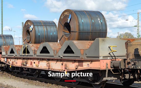 A freight train with wagons loaded with steel rolls and the signature Sample picture